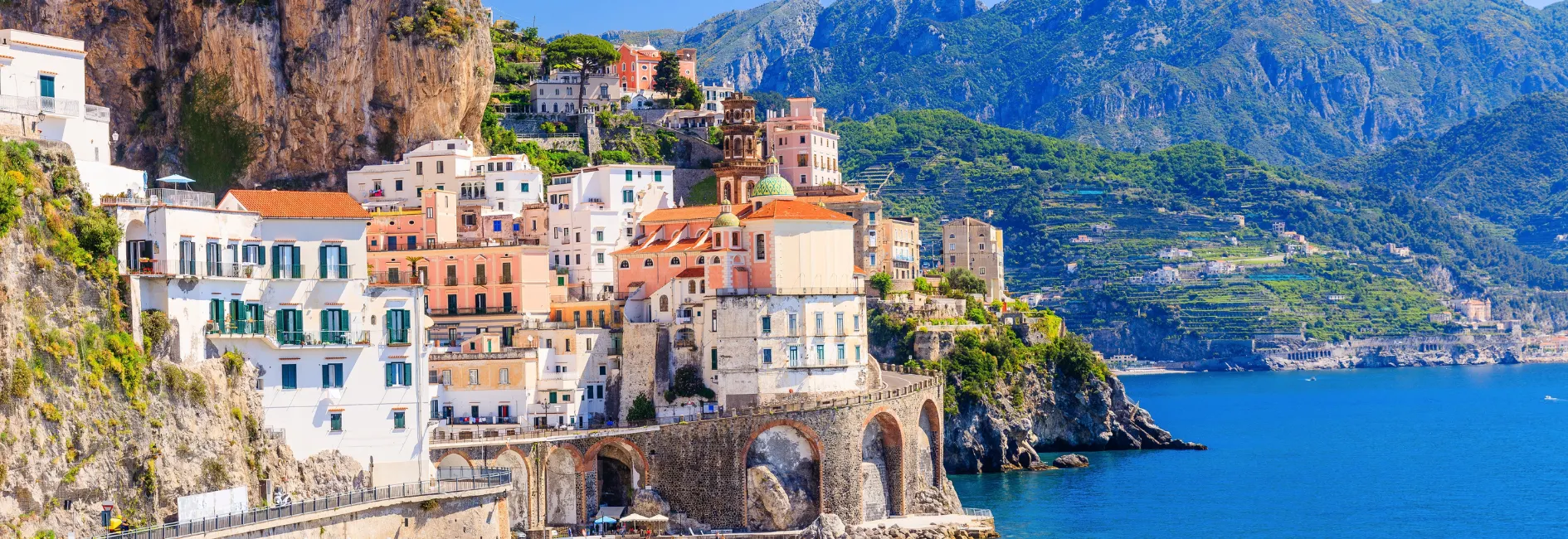 Wit/oranje huizen gebouwd op een klif aan het water
