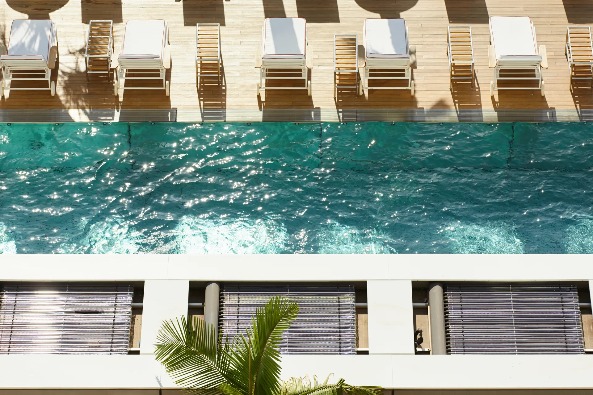 Zwembad van boven met aan de zijkant ligstoelen