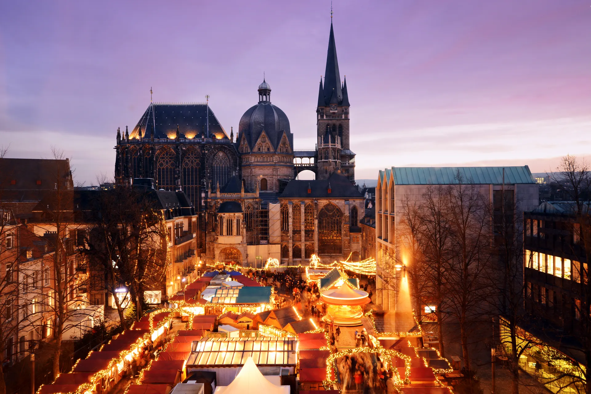Plein met kerstkraampjes, kerstverlichting en dom op de achtergrond