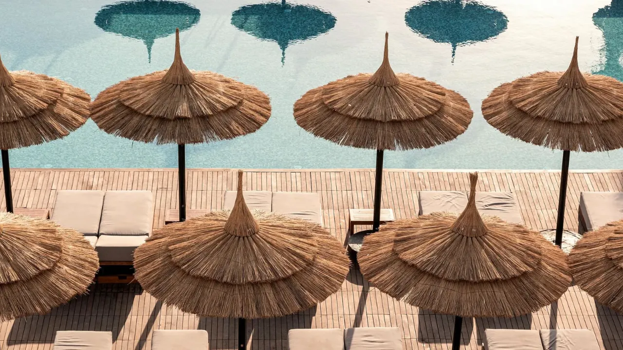 Zwembad vanaf vogelperspectief met ligbedden en parasol