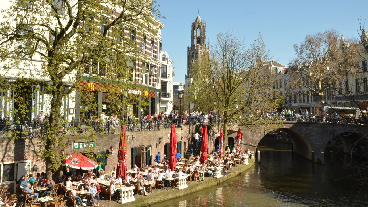 Gracht in Utrecht met direct aan gracht een terras met stoelen en tafels