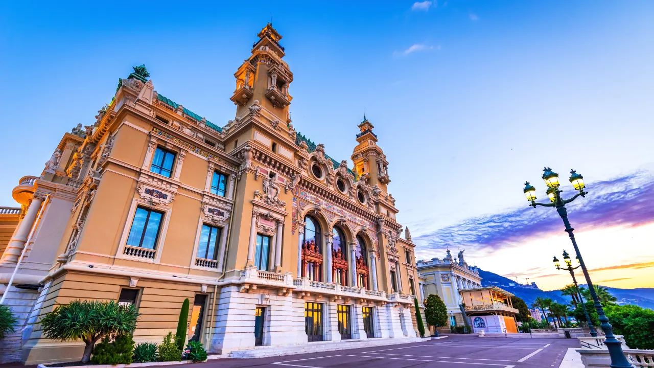 Geel/wit gebouw met op de achtergrond  blauw/paarse lucht in Monaco