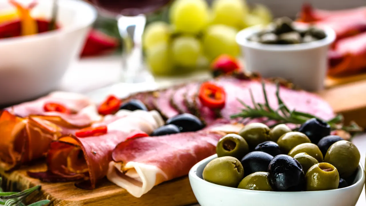 Close up van verschillende soorten tapas waaronder olijven, ham en druiven