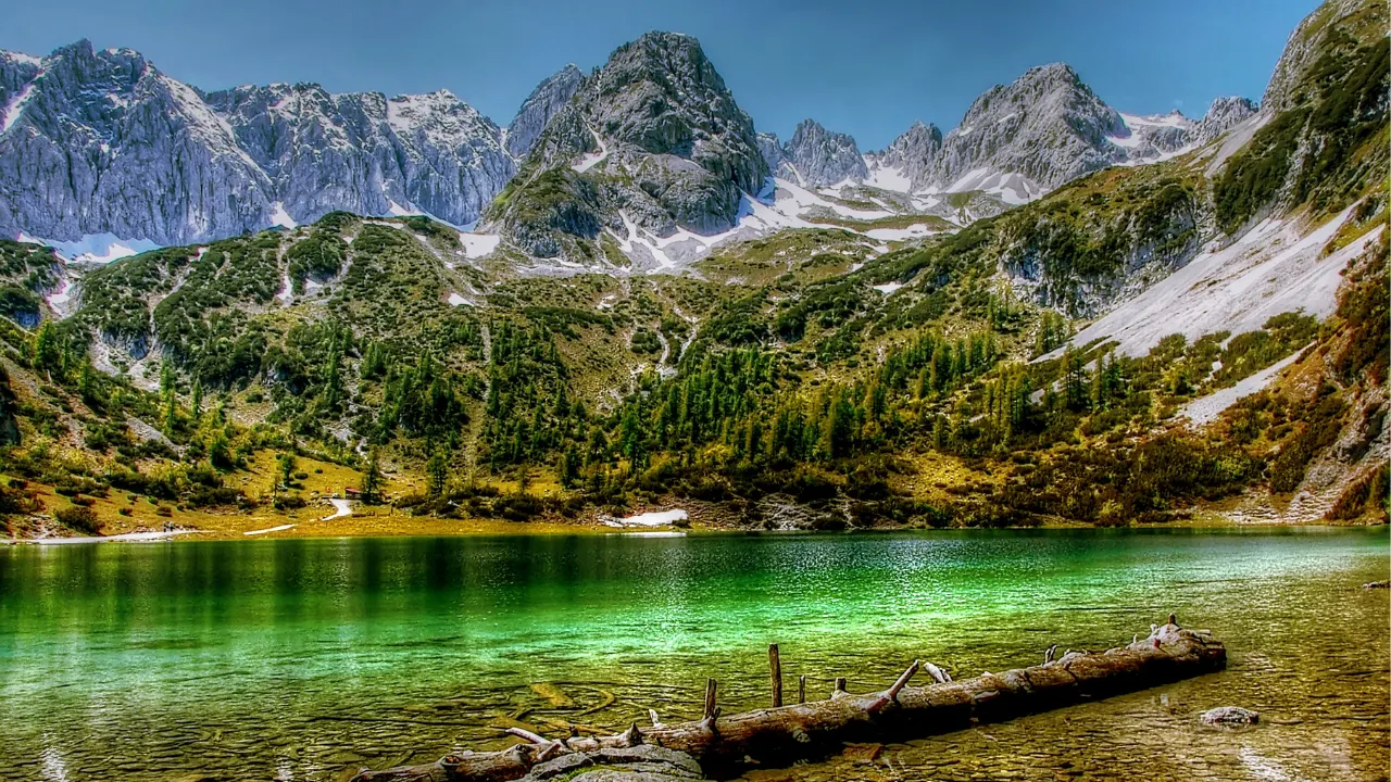 Bergen op de achtergrond met groot groen gekleurd meer 