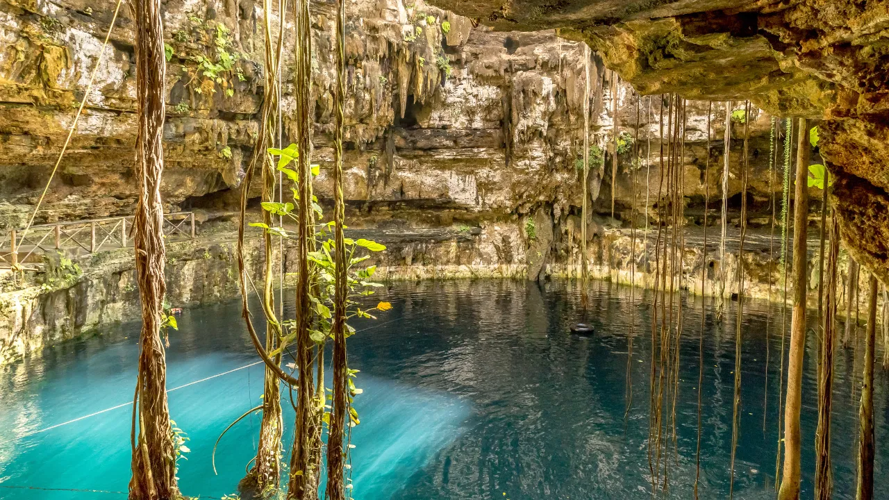 Cenotes grotten met helderblauw water en gele/grijze rotsen aan de zijkant