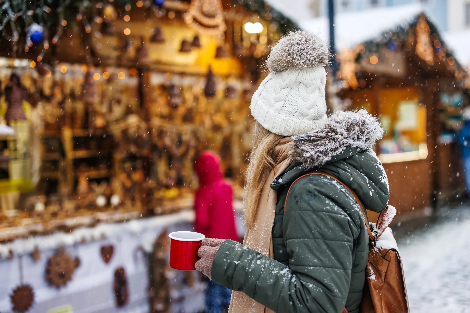 Vrouw op kerstmarkt met mok in linkerhand