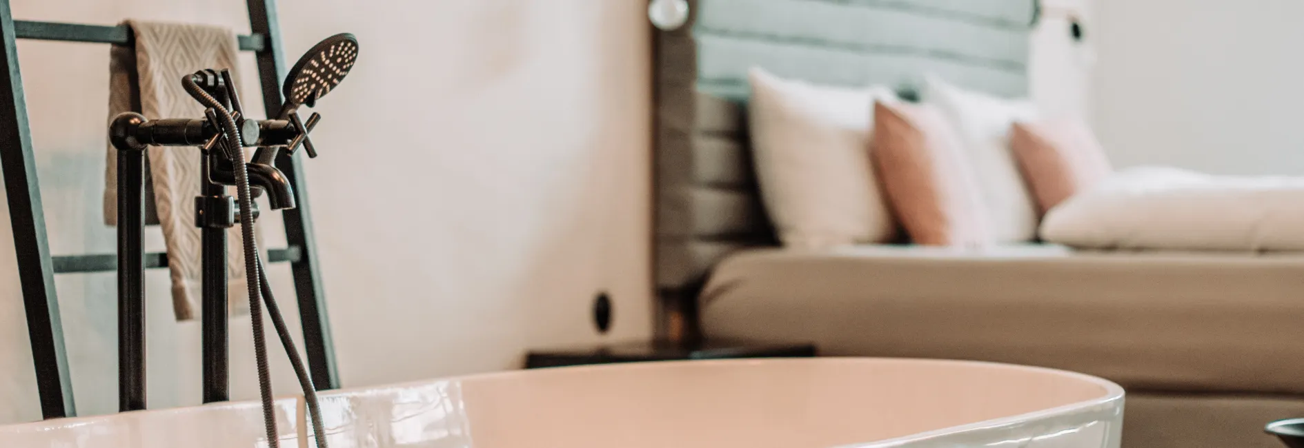 Bad met zwarte douchekop met op de achtergrond bed