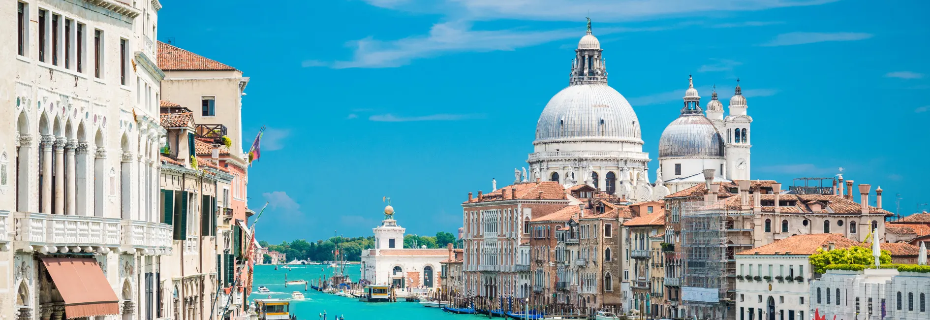 Witte gebouwen met rechts achterin een grote kathedraal en tussen de gebouwen en blauwe zee als gracht