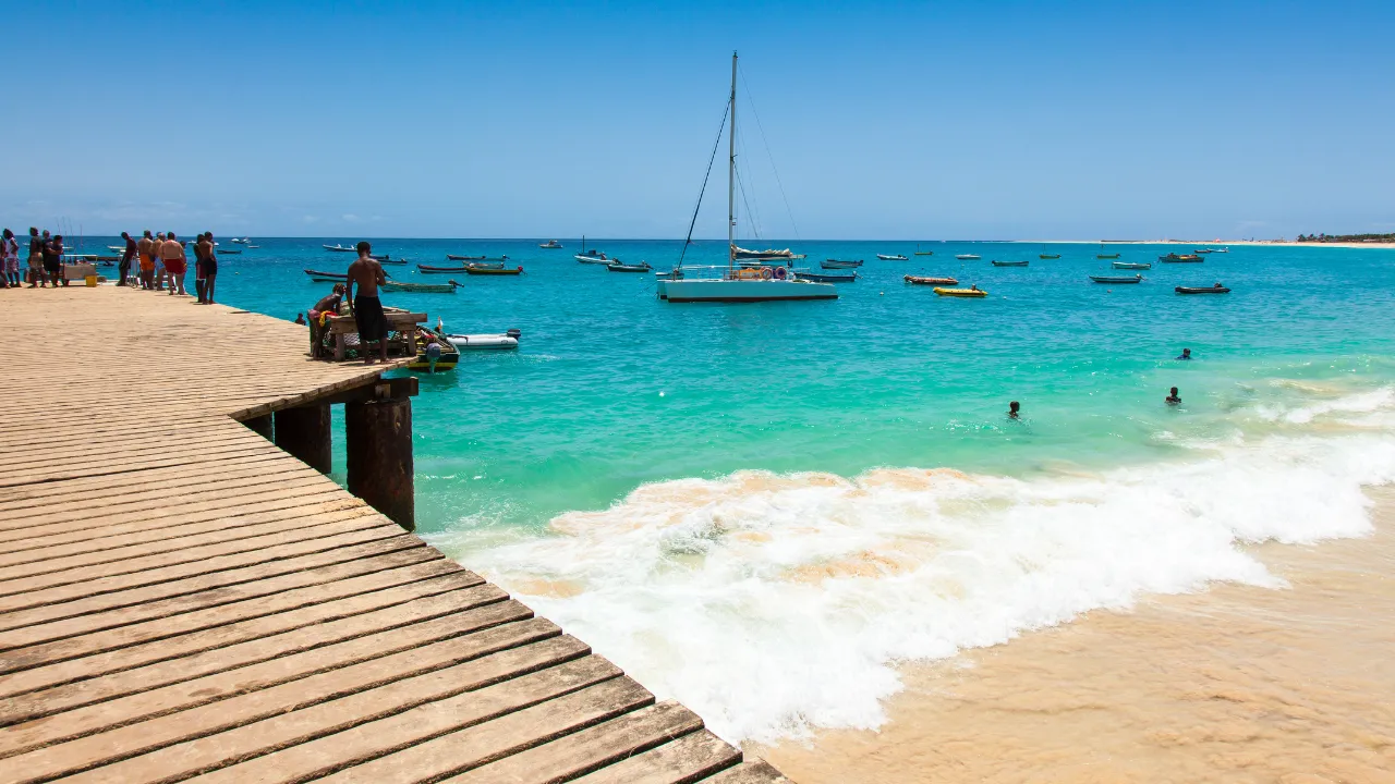 Strand met helderblauw water en goud strand met boten in het water