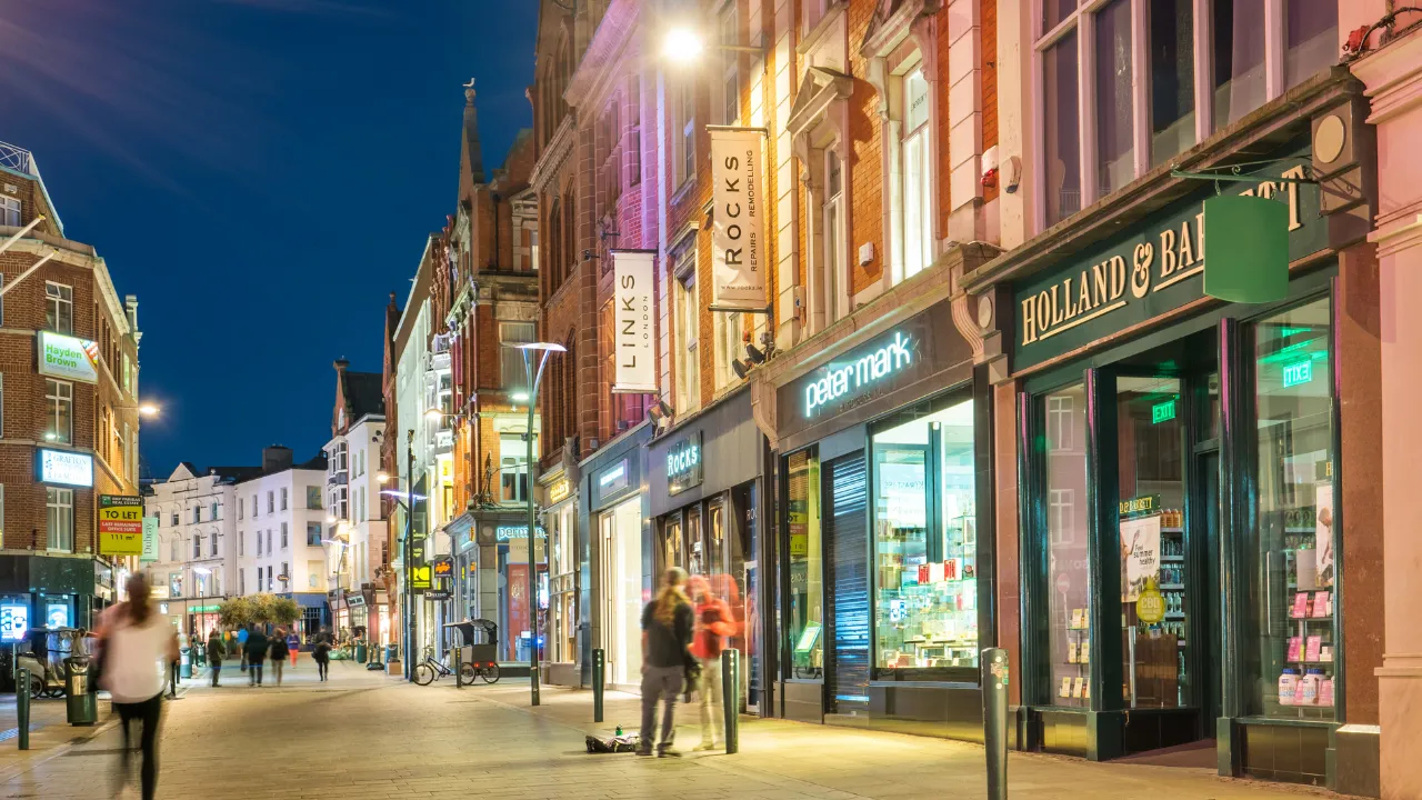 Winkelstraat in de avond verlicht door lichtjes en etalages