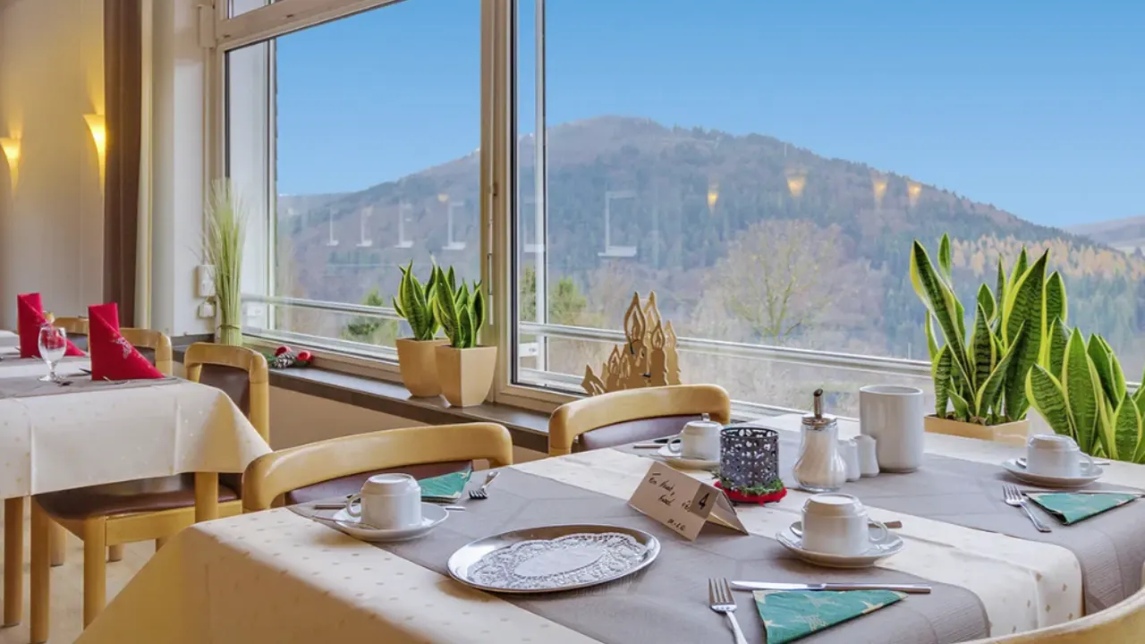 Ontbijttafel in eetruimte naast raam met uitzicht over de bergen in Winterberg