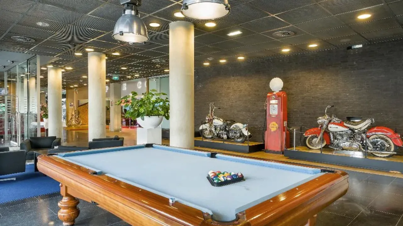 Pool tafel in Select Hotel Maastricht met op de achtergrond tentoongestelde motoren