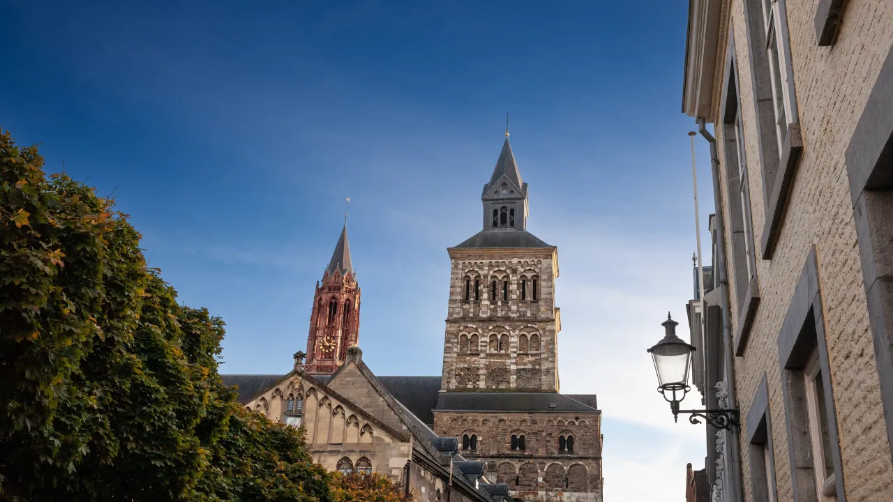 Kerktoren in straatje in Maastricht vanuit kikkerperspectief