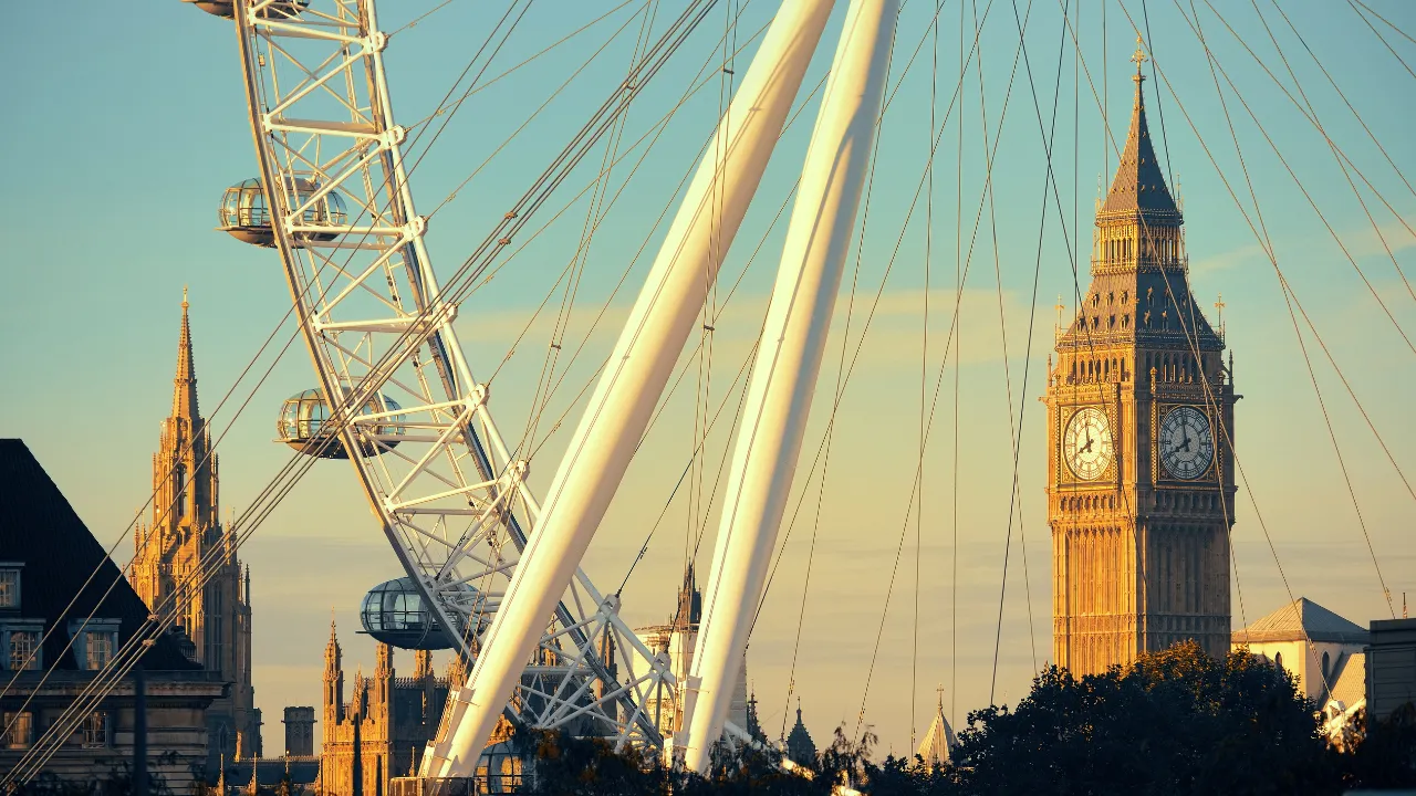 London Eye met op de achtergrond de Big Ben met geel/blauwe lucht 