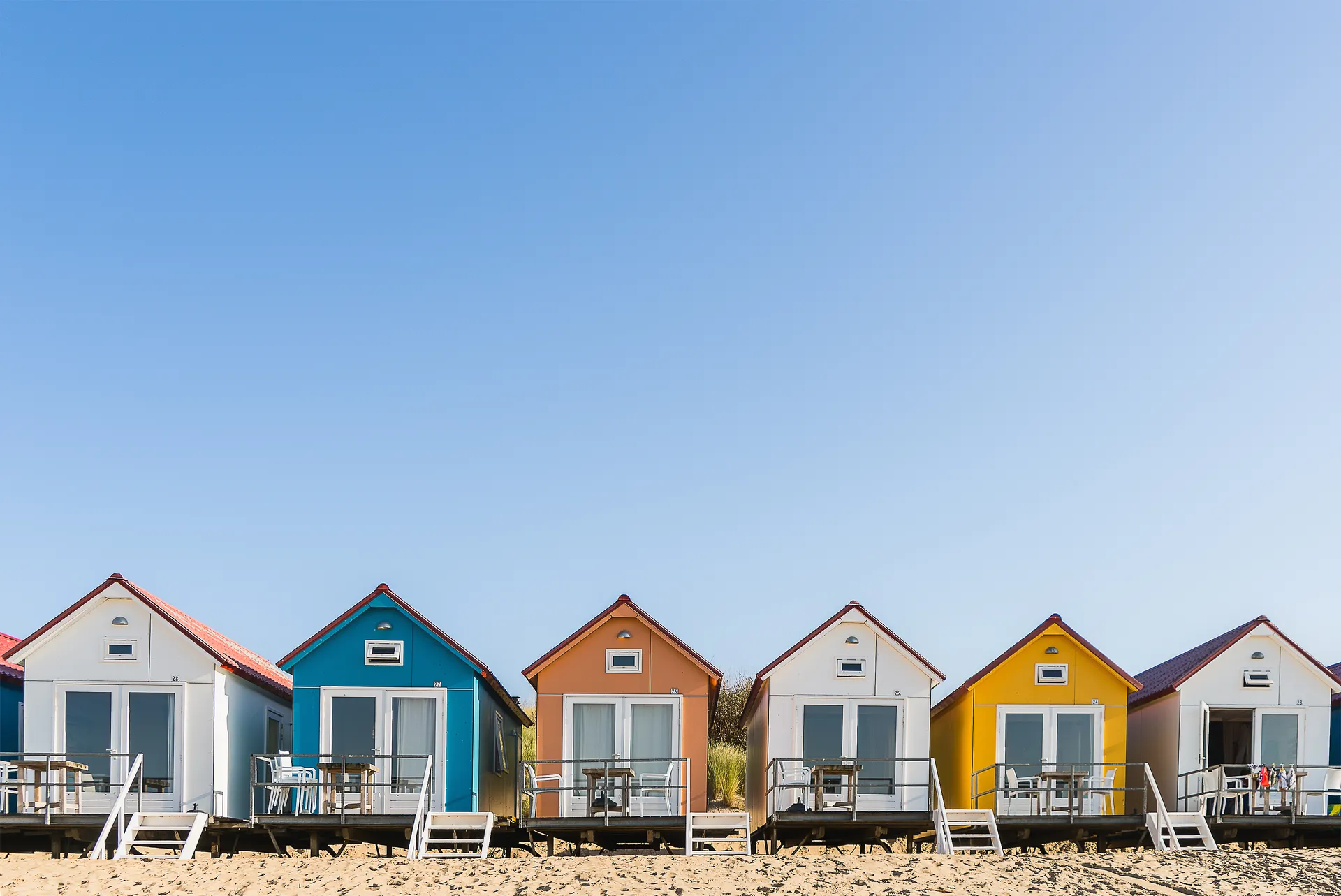 Gekleurde huisjes op een rij op het strand