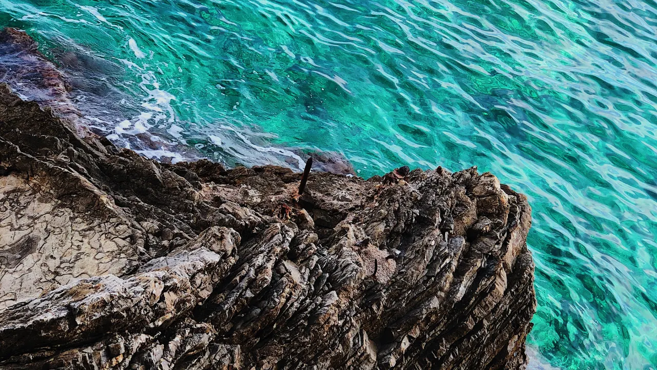 Blauwe zee met zwarte rotsen