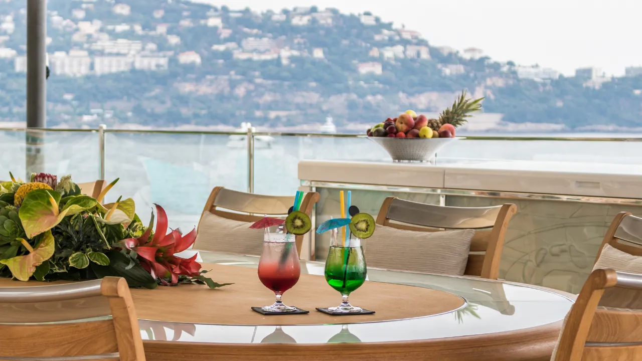 Twee cocktails op tafel met op de achtergrond bergen